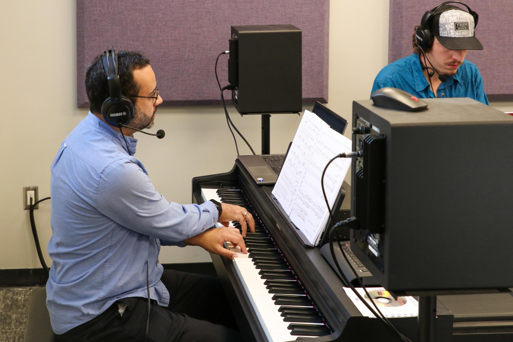 Instructor and student with pianos